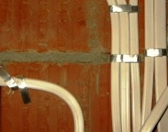 Крепление провода к стене с помощью металлических полосок